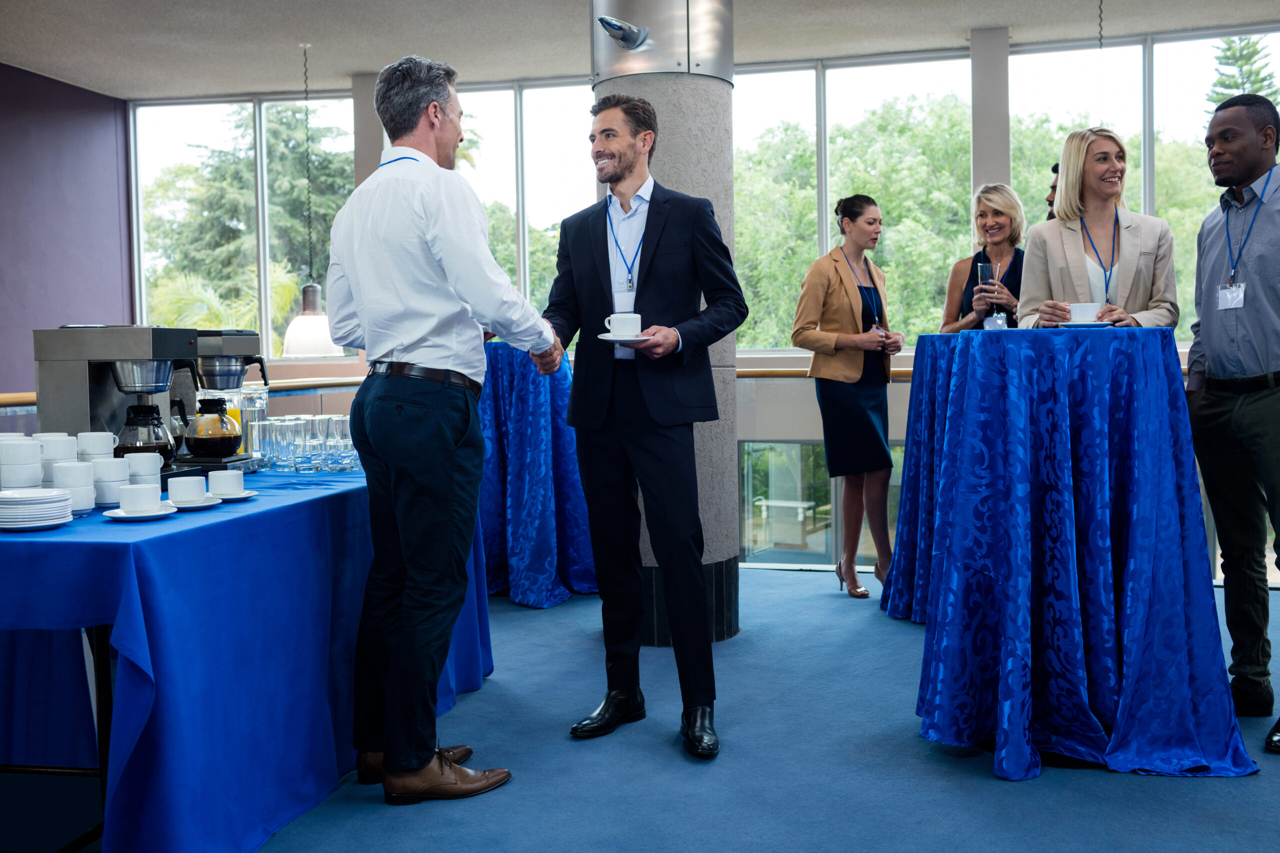 Business executives interacting with each other while having coffee at conference center