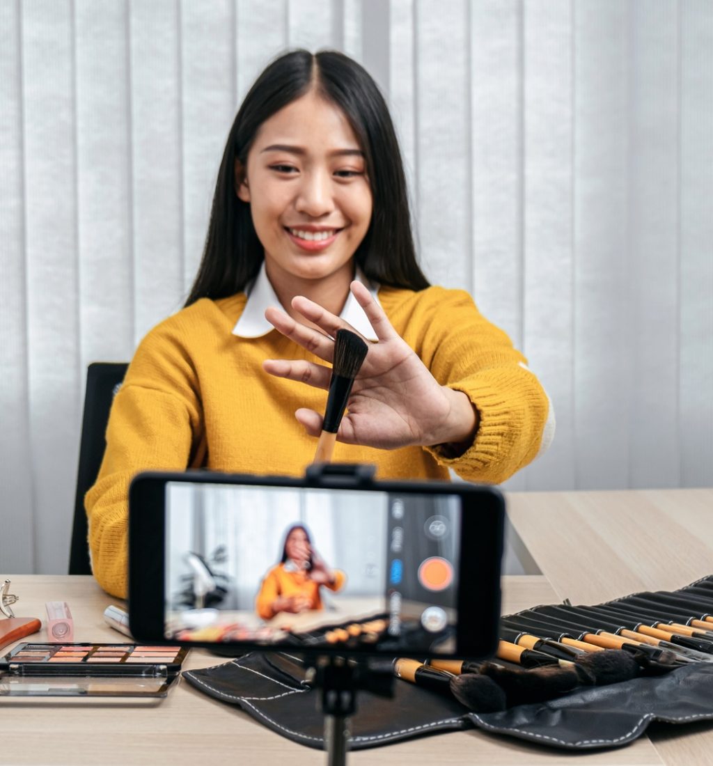 Female beauty blogger holding brush for review the quality of pr